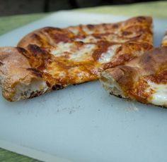 two slices of pizza sitting on top of a cutting board