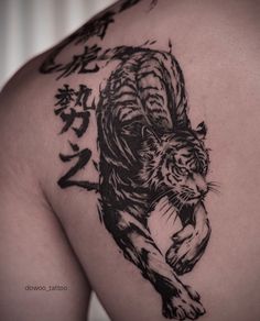 a tiger tattoo on the back of a man's shoulder and chest is shown