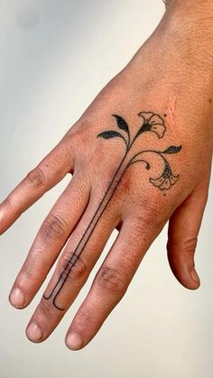 a person's hand with a flower tattoo on it