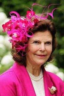 an older woman with pink flowers in her hair