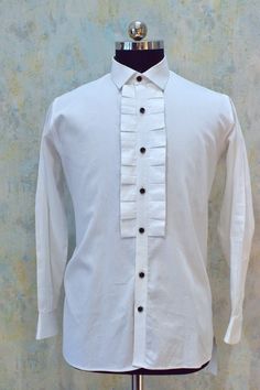 White ruffle tuxedo shirt for men's made with scrupulous attention. This tuxedo shirt is made in cotton fabric and has ruffle design on the front side. This white  party shirt is designed in such a way that it could be worn with tuxedos, suits, blazers and also it could be worn solely (i.e. only pant and shirt). Components : 1 Fabric : Giza Cotton Neckline : Straight Collar Other Details : Ruffle Design  Cuff : Barrel Cuff (French cuff could also be made on request) Color : White Fitted White Shirt With Ruffles, Formal White Ruffled Shirt, White Ruffled Shirt For Formal Occasions, Classic Formal Shirt With Ruffles, Fitted Cotton Shirt For Wedding, Classic Cotton Shirt With Ruffles, Mens White Dress Shirt, Mens Dress Shirts, Tuxedo Shirt