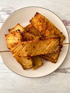 grilled pineapple slices on a plate with toothpicks