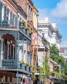 people are walking down the street in front of buildings with balconies on them