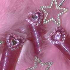 two pink hair clips with hearts and stars on them, sitting next to each other