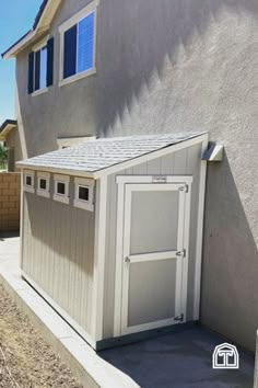 a small storage shed in front of a house