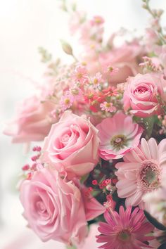 a bouquet of pink roses and daisies on a white tablecloth with blurry background