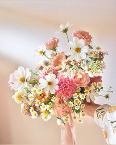 a person holding a bouquet of flowers in their hand