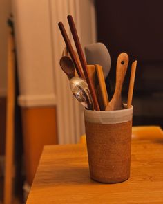 a cup filled with spoons and other kitchen utensils