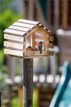 a small bird house on top of a wooden post