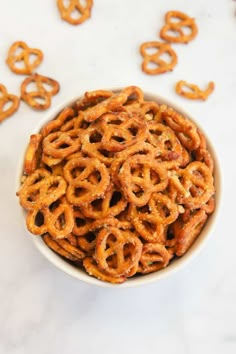 a bowl filled with pretzels sitting on top of a white counter next to other items