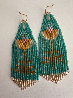 two pairs of beaded earrings on a white surface