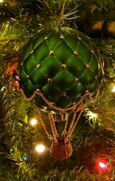 a green ornament hanging from a christmas tree