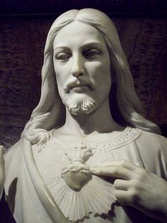 a statue of jesus holding a heart in his hands