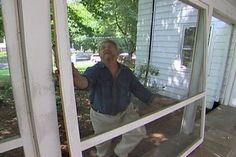 a man standing in front of a window talking on a cell phone