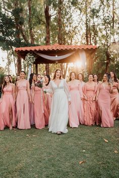 a bride and her bridal party posing for a photo in front of the gazebo