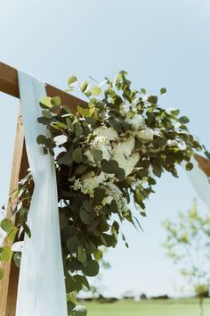 a wedding arch with white flowers and greenery