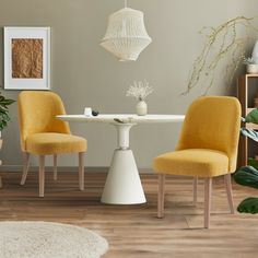 two yellow chairs sit at a white table in front of a plant and potted plants