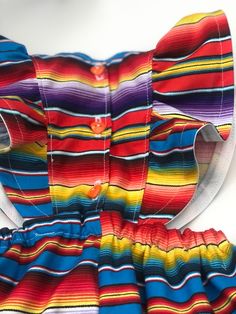 Perfect for all the summer 🥳 FIESTAS!! Handmade skirt romper. Made with cotton serape cotton fabric. These amazing pieces are made to order. Sizes 0-6 month up to 4T are made with attached bloomers and snaps at the saddle. Anything above a 4t (5t -7/8y) are the same style dress with no bloomers attached. If you have any questions on sizing please don't hesitate to message me. I will gladly help. Rainbow Cotton Dress For Playtime, Rainbow Cotton Playtime Dress, Multicolor Summer Sundress For Playtime, Playful Multicolor Ruffled Sundress, Fun Multicolor Sundress For Playtime, Multicolor Cotton Dress For Playtime, Multicolor Ruffled Dresses For Festival, Multicolor Ruffled Festival Dress, Multicolor Sundress For Playtime