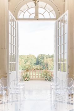 an open door leading to a balcony with clear chairs