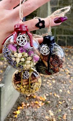 a person's hand holding three ornaments in the shape of mushrooms and plants, with other decorations hanging from them