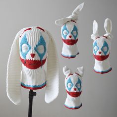 three knitted hats with bunny ears and eyes on top of each other, one wearing a red white and blue sweater