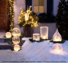 lighted snow globes in front of a house