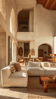 a living room filled with lots of furniture next to a tall wall covered in windows