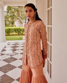 Editor's Note This set features Full sleeves kurta with overall hand embroidery in alternate mirror work and floral stripes. It has faux potli button detailing. It is paired with a tiered cheeta embroidered sharara Color: Rose Gold Fabric: Georgette and net Care: Dry Clean Only About the Designer Sanya gulati's designs are inspired by the Indian bridesmaids, pastel easy hues & the seasonal trends, her designs is a mix of modern, contemporary embroideries with traditional silhouettes thus creatin Peach Embroidery, Potli Button, Rose Gold Fabric, Ruffle Dupatta, Embroidered Sharara, Blouse Yoke, Indian Bridesmaids, Kurta Set For Women, Sanya