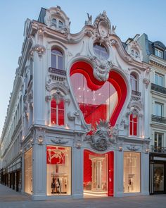 the facade of a building with red and white decorations on it's windows,