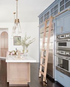 a kitchen with an oven and ladder in it