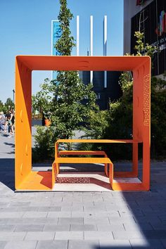 an orange bench sitting in the middle of a walkway