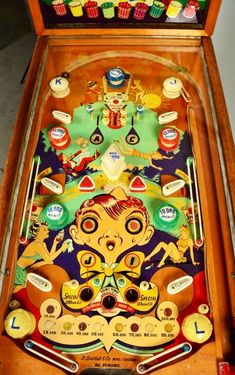 an old fashioned pinball machine with many items in it