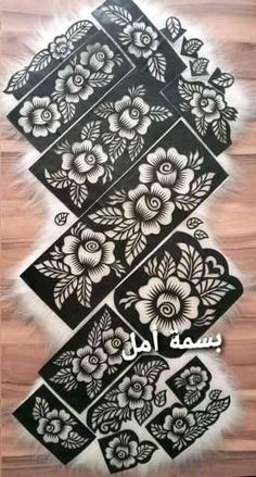 an arabic calligraphy written in black and white on a wooden floor with floral designs