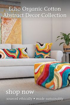 a white couch with colorful pillows on it and the words echo organic cotton abstract decor collection