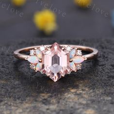 an engagement ring with pink opal and white topazte surrounded by small diamonds