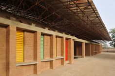 an empty building with multiple colored shutters on the walls and in front of it