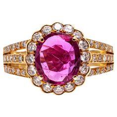 18k Yellow Gold Pink Sapphire And Diamond Cluster Ring This striking ring is a cluster style, set with a faceted oval shape, medium pink color lab created pink sapphire center, prong set. Surrounding the stone is a halo of round brilliant cut diamonds, set with a scalloped edge, and decorated with a three row, round faceted diamond set shank. The entire diamond weight for the ring is approximately 0.47 TCW. Marks: 18k Dimensions: 13/16" across the top x 1/2" wide Weight: 4.2 gross dwt Classic Pink Cluster Ring For Formal Occasions, Formal Pink Cluster Ring With Brilliant Cut, Classic Pink Cluster Ring With Center Stone, Classic Pink Diamond Cluster Ring, Classic Pink Cluster Ring With Prong Setting, Gia Certified Oval Pink Diamond Ring, Oval Pink Gia Certified Diamond Ring, Pink Oval Cluster Ring Fine Jewelry, Luxury Pink Oval Cluster Ring