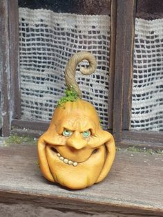 an odd looking pumpkin sitting on top of a window sill