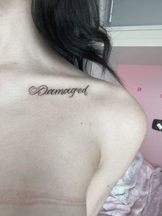 a woman with a tattoo saying damaged on her chest and the word changed written in cursive font