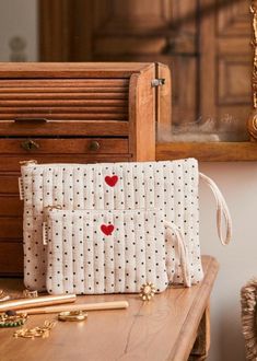 a purse sitting on top of a wooden table next to a mirror and other items