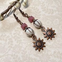 Super cute boho earrings perfect for everyday!  These are created using white Czech glass melon beads with a brown wash, pink Strawberry Quartz rondelles, and antique copper sun charms.  I have also used antique copper accents, and nickel free, fish hook ear wire.  Total length of earrings, including the ear wire, is approximately 2-1/4".    Thank you for shopping with The Lucie Collection! White Wire Wrapped Bohemian Earrings, White Bohemian Wire Wrapped Earrings, Bohemian White Wire Wrapped Earrings, Nickel Free White Bohemian Earrings, White Bohemian Earrings With Czech Glass, White Bohemian Beaded Earrings Nickel Free, Nickel-free White Bohemian Earrings, Bohemian Nickel-free White Earrings, Bohemian White Nickel-free Earrings