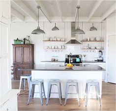 a kitchen with white walls and wooden floors