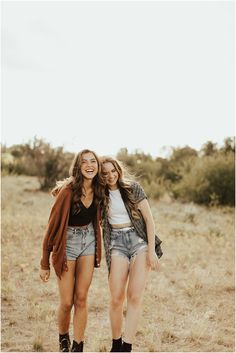 two young women are walking together in the field