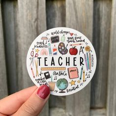 a person holding up a sticker with the words teacher written in different languages on it