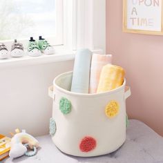 a white bucket filled with lots of different types of items next to a window sill