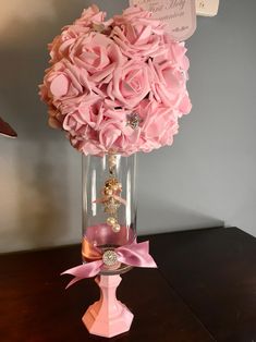 a vase filled with pink flowers on top of a wooden table