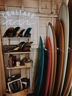 several surfboards are lined up against a wall