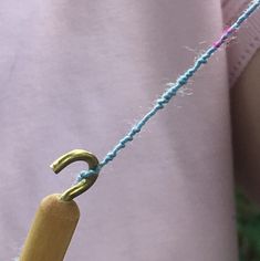 a close up of a person's hand holding a string with an umbrella on it