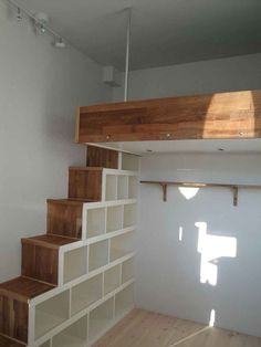 there is a room with some stairs and shelves on the wall in front of it