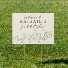 a sign in the grass that says welcome to abigail's first birthday